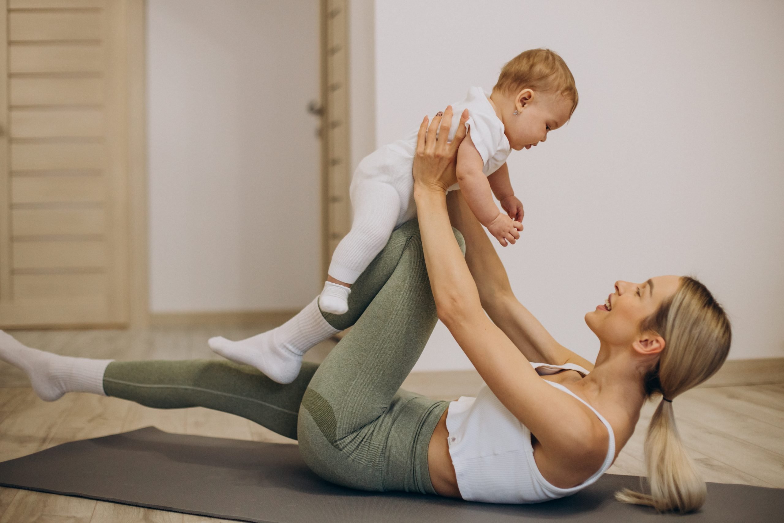 mother practicing yoga with her baby daughter at home
